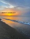 Don\'t forget, affirmation. Sea waves rolling onto sandy beach at sunrise