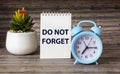 Don`t forget reminder on notepad and wooden background