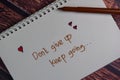 Don`t Give up Keep Going write on a book isolated wooden table