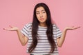 Don`t know answer! Portrait of clueless confused girl with long hair in striped t-shirt raising hands in bewilderment Royalty Free Stock Photo