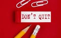 DON`T QUIT message written under torn red paper with pencils and clips, business Royalty Free Stock Photo