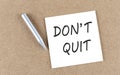 DON\'T QUIT text on sticky note on a cork board with pencil Royalty Free Stock Photo