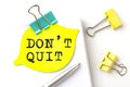 DON`T QUIT text on yellow sticker on notebook with pen Royalty Free Stock Photo