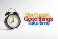 DON`T RUSH GOOD THINGS TAKE TIME inscription written and alarm clock on white background Royalty Free Stock Photo