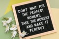 Don`t wait for the perfect moment, take the moment and make it perfect. Motivational quote on letter board frame and flower orchi