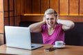 Dont want to hear! Portrait of attractive young girl freelancer in pink t-shirt is sitting in cafe and working on laptop, covering