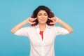 Don`t want to listen! Irritated angry woman with red hair standing with closed ears and eyes not to hear annoying sound