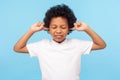 Don`t want to listen. Portrait of disobedient capricious little boy with curly hair covering ears Royalty Free Stock Photo