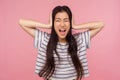 Don`t want to listen! Portrait of irritated girl with brunette hair covering ears and shouting with crazy expression