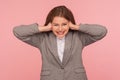 Don`t want to listen! Portrait of irritated stressed out young woman in business suit tightly covering ears