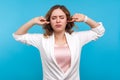 Don`t want to listen! Portrait of resentful girl covering ears and closed eyes in displeasure. studio shot