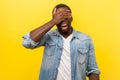 Don`t want to watch. Portrait of panicked frightened man standing with covered eyes. indoor studio shot isolated on yellow