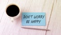 DON`T WORRY BE HAPPY text on the blue sticker with cofee and pen Royalty Free Stock Photo