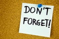 don& x27;t forget written on color sticker notes over cork board background Royalty Free Stock Photo