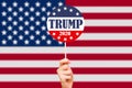 Donald Trump campaign button on the background of the USA flag. Election of the President of the United States of America