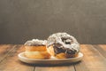 Donat. Donat in chocolate is strewed with grated almonds. Donat in a white bowl on a dark background with copy spacw