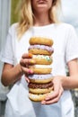 Donat tower. Woman holding a stack of different sweet colorful glazed donuts Royalty Free Stock Photo