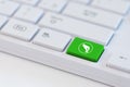 Donate concepts. Green key with hand and coin icon on white laptop keyboard Royalty Free Stock Photo