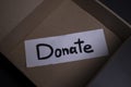 `Donate` sign handwritten with black letters in a box. donation concept. Context of The Coronavirus Pandemic. copy space