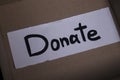 `Donate` sign handwritten with black letters in a box. donation concept. Context of The Coronavirus Pandemic. copy space