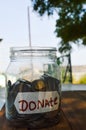 donate written text in plastic jar and money,coins in donate box or jar,money in donate written jar,charity box in coins,money in