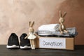 Donation box clothes and toys on wooden table Royalty Free Stock Photo