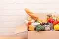 Donation box with different groceries, food donations on light background with copyspace - pasta, fresh vegatables, canned food, Royalty Free Stock Photo