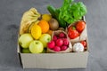 Donation box with fresh organic fruits, vegetables and herbs on a concrete background. Proper nutrition. Royalty Free Stock Photo