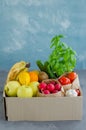 Donation box with fresh organic fruits, vegetables and herbs on a concrete background. Proper nutrition. Royalty Free Stock Photo