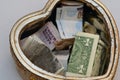 A donation box with a heart shape, collecting money for charity, helping poor people, a box with a multi currencies Royalty Free Stock Photo