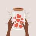 Donation concept. African female hands holding glass jar full of red hearts. International charity day. Share your love Royalty Free Stock Photo