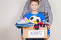 Donation concept. Donate box with clothes, books and toys in child and mother hand Royalty Free Stock Photo