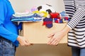 Donation concept. Donate box with clothes, books and toys in child and mother hand Royalty Free Stock Photo