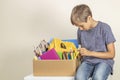 Donation concept. Kid holding donate box with books, pencils and school supplies