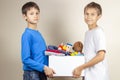 Donation concept. Kids holding donate box with books, clothes and toys