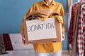 Donation concept. Woman holding Donation box with donation clothes in her home. Charity. Helping poor people. Royalty Free Stock Photo