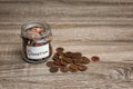 Donation jar and coins on wooden table. Royalty Free Stock Photo