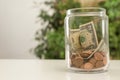 Donation jar with money on table against blurred background Royalty Free Stock Photo