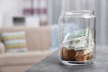 Donation jar with money on table against blurred background. Royalty Free Stock Photo