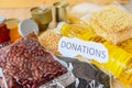 Donations food with canned food on wooden table background / pasta canned goods and dry food non perishable with pea beans cooking Royalty Free Stock Photo