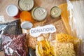 Donations food with canned food on wooden table background / pasta canned goods and dry food non perishable with pea beans cooking Royalty Free Stock Photo