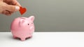 Donations of love and feelings, sympathy. Man puts heart in piggy bank. Copy space for text. Royalty Free Stock Photo