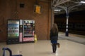 Woman with long curly brunette hair decides which vending machine