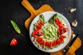 Doner kebab cut into pieces served with tomatoes and hot peppers on white plate on dark background Royalty Free Stock Photo