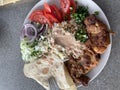 Doner kebab or gyros on a plate with french fries, pita bread and salad. Royalty Free Stock Photo