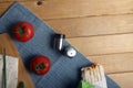 Doner kebab, lavash on cutting board, tomato and salt shaker on wooden background flat lay