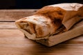 Doner kebab is lying on the cutting board.Shawarma with meat, onions, salad lies on a dark old wooden table. Royalty Free Stock Photo