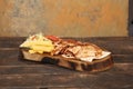 Doner kebab is lying on the cutting board. Shawarma with meat, onions, salad lies on a dark old wooden table Royalty Free Stock Photo