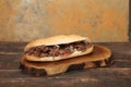 Doner kebab is lying on the cutting board. Shawarma with meat, onions, salad lies on a dark old wooden table Royalty Free Stock Photo