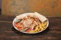Doner kebab is lying on the cutting board. Shawarma with meat, onions, salad lies on a dark old wooden table Royalty Free Stock Photo